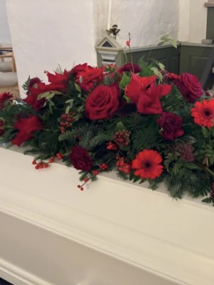 Kistepynt med sæsonens blomster i røde nuancer