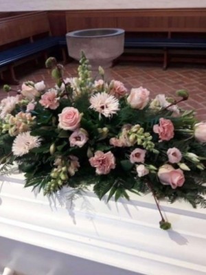 Kistepynt med sæsonens blomster i lyserøde nuancer