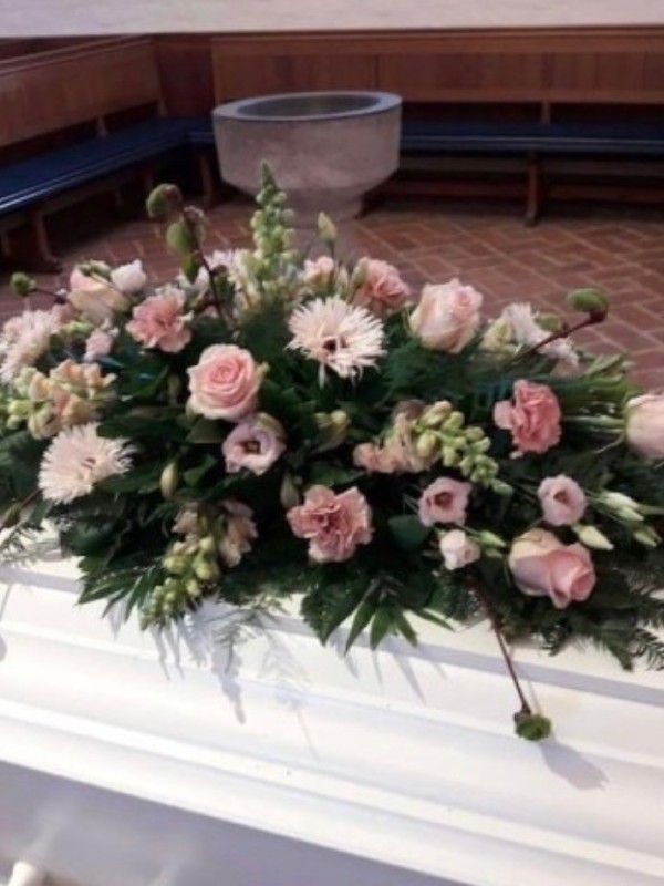 Kistepynt med sæsonens blomster i lyserøde nuancer