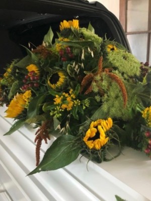 Kistepynt med sæsonens blomster i gule nuancer