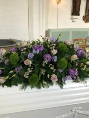 Kistepynt med sæsonens blomster i lilla nuancer