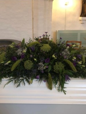 Kistepynt med sæsonens blomster i grønne nuancer