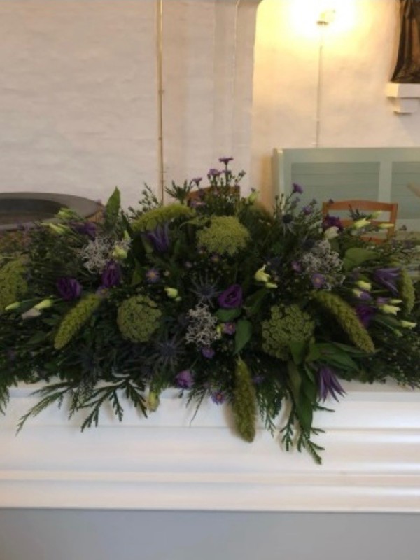 Kistepynt med sæsonens blomster i grønne nuancer