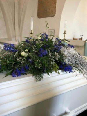 Kistepynt med sæsonens blomster i blå nuancer